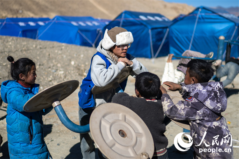 西藏星光社會工作服務中心社工久米旦增通過聊天談心，對孩子們進行災后心理疏導。人民網記者 翁奇羽攝